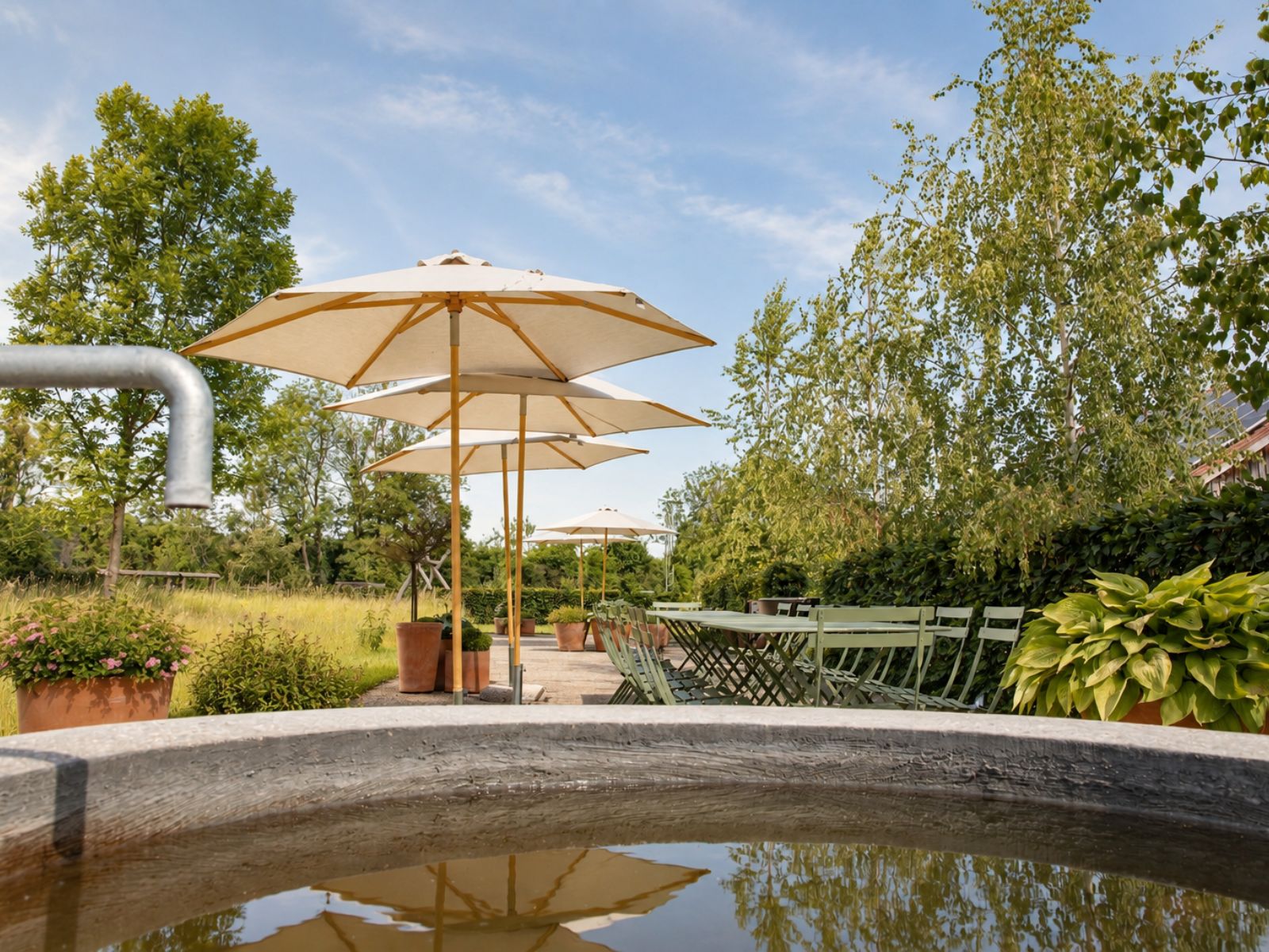Garten der d’Kammer mit Liegeplätzen unter einem Sonnenschirm